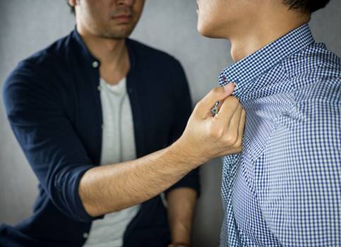 Man grabbing coworkers shirt - Hostile Work Environment